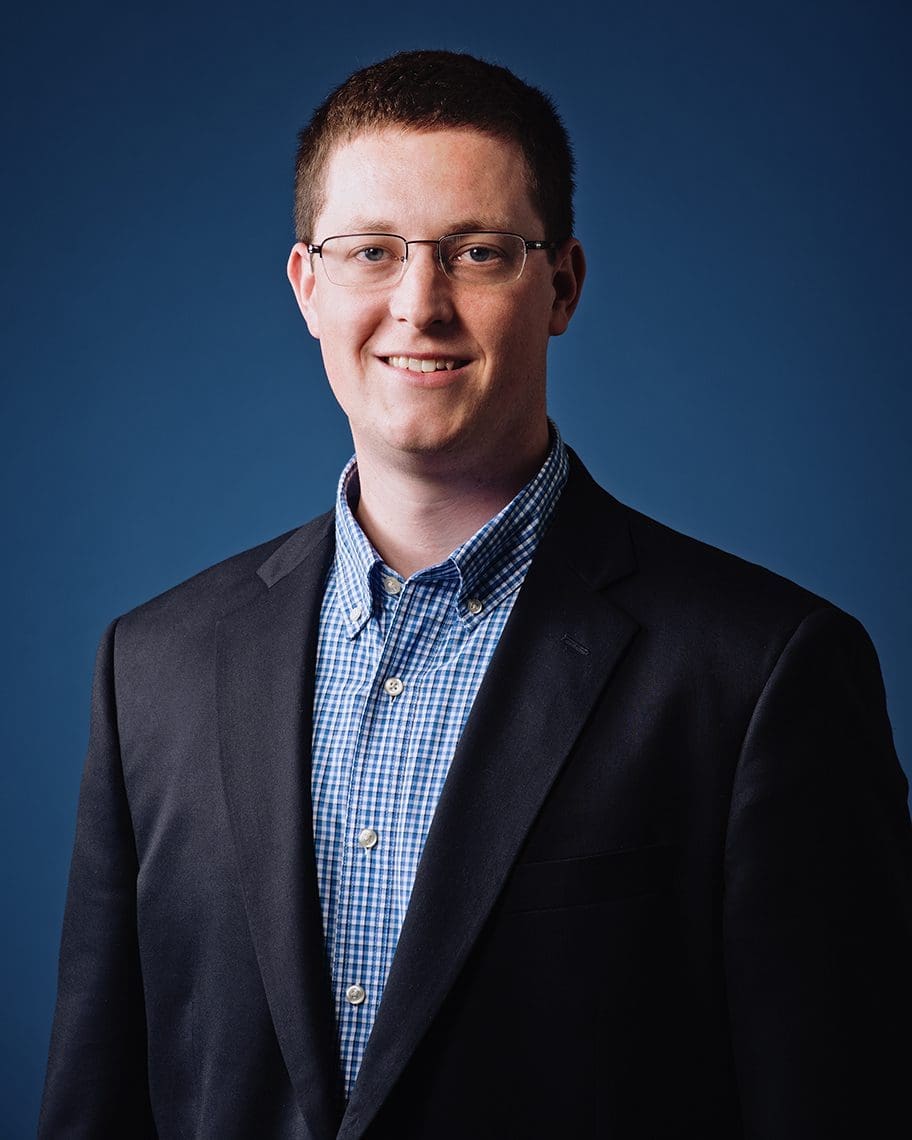 Tall smiling man wearing a suit.